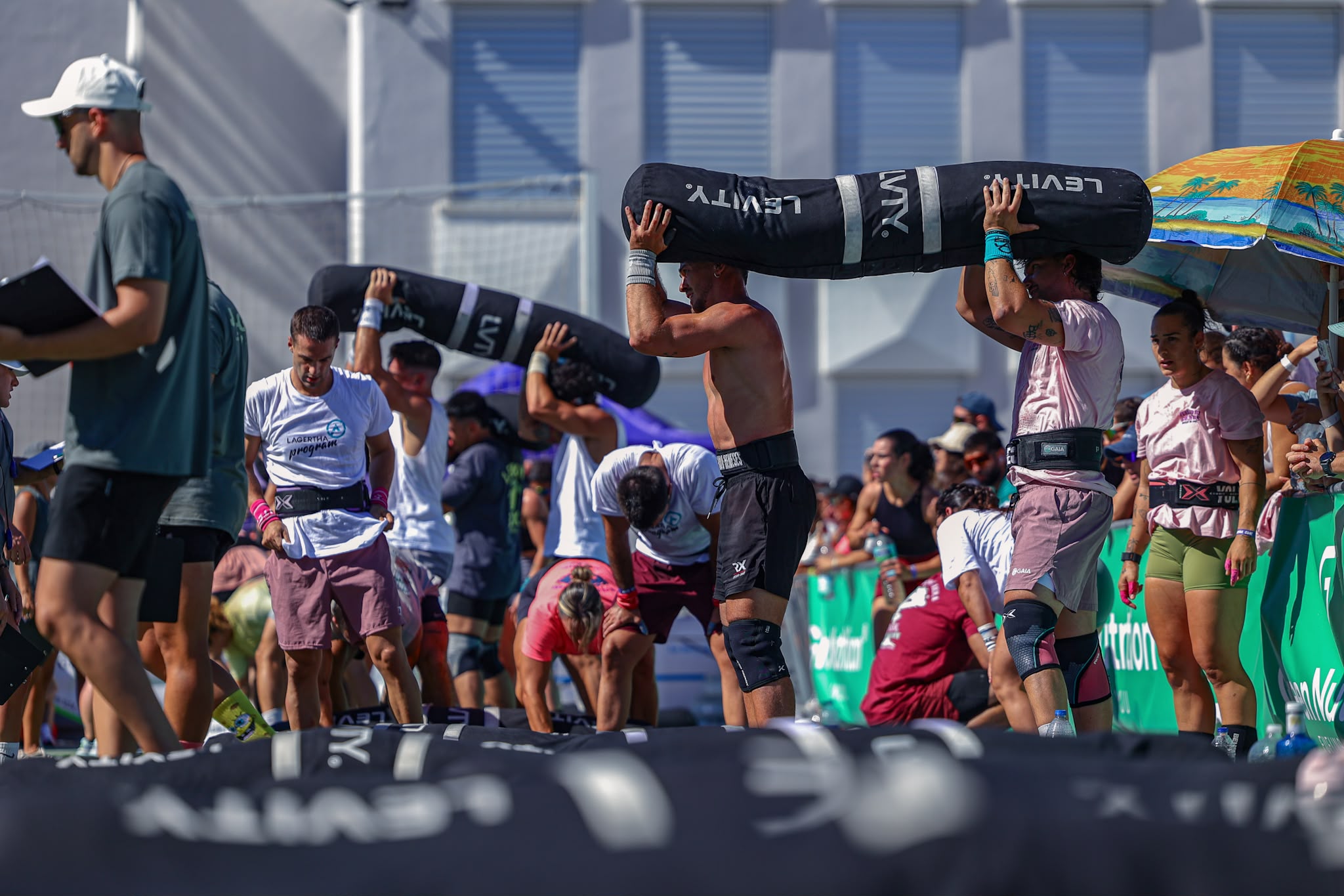 Teams lift weighted bags overhead during Cádiz Throwdown 2026