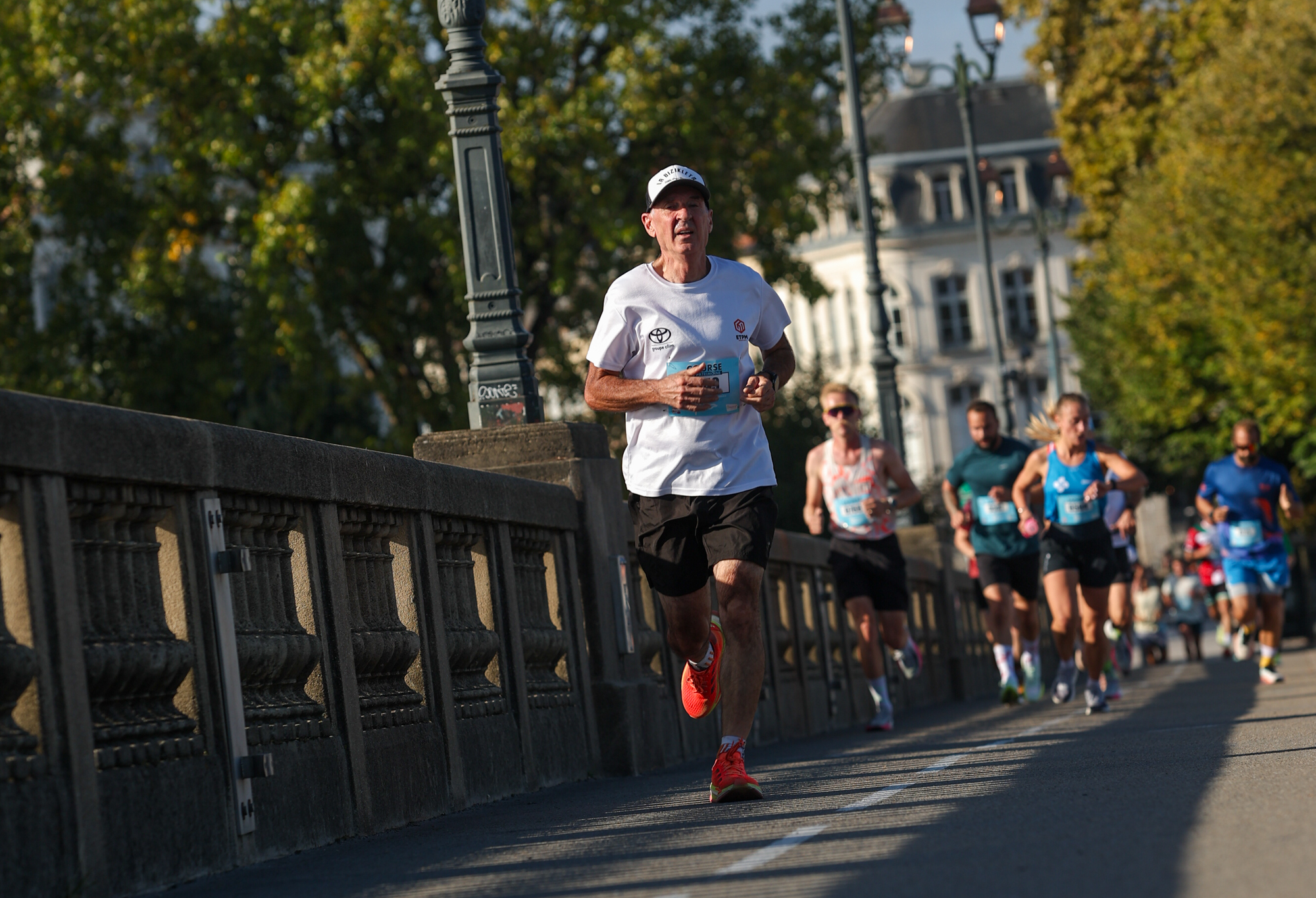 Runners beside a stone balustrade during the Course du Patrimoine in Bayonne